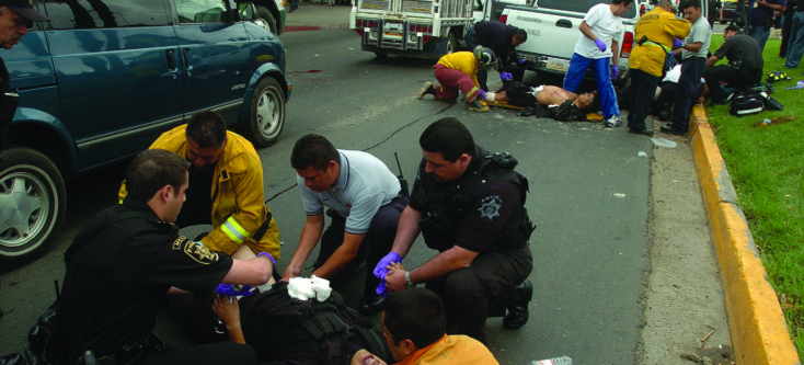 A shootout with drug traffickers and their hit men claimed more victims in Tijuana, Mexico. The downed policeman in the distance would die.