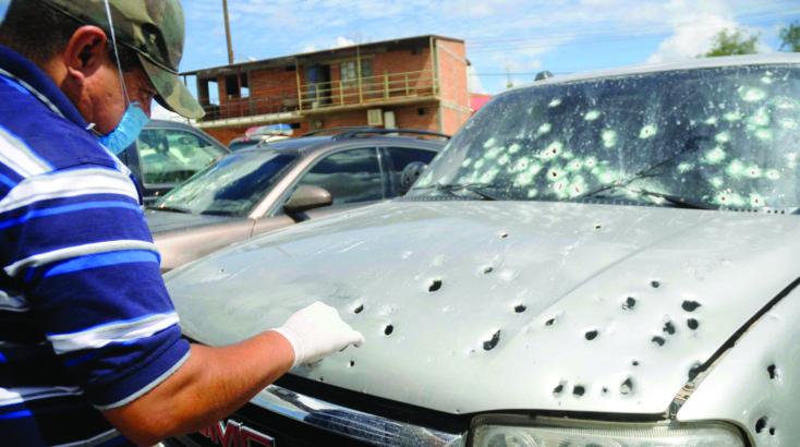 A police investigator looks for evidence following a drug-related hit in Hermosillo, Mexico.
