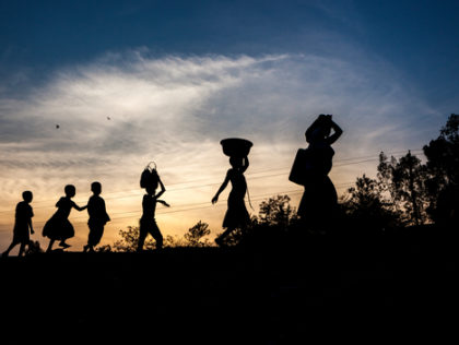 Women and children walk at sunset on a road near Uvira, Democratic Republic of the Congo (DRC), one of the main transit points for Burundian refugees crossing the border.